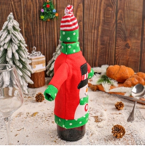Detail of knitted snowman wine bottle cover with hat and sleeves on a wooden background