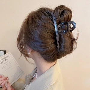 Detail of dark grey tortoise shell hair claw clip with glossy finish for thick hair