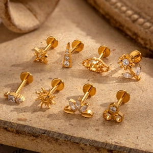 8-piece gold G23 titanium cartilage stud set with zircon star, leaf, and sun designs