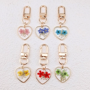 Set of six heart-shaped resin keychains with natural dried flowers and gold metal lobster clasps
