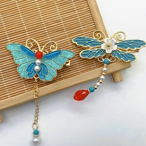 Detail of vintage enamel butterfly and dragonfly hair clips with pearls and tassels
