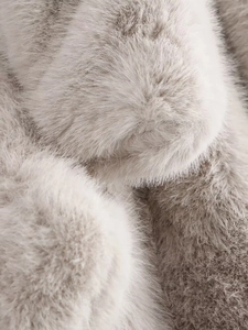 Gros plan sur la texture en fausse fourrure grise montrant des fibres denses et soyeuses