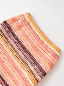 Detail von Strickstoff mit Pailletten und bunten Streifen in Rosa, Orange und Weiß