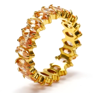 Macro shot of gold-plated eternity ring with oval amber cubic zirconia stones