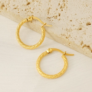 18k gold plated stainless steel twisted hoop earrings on minimalist stone background