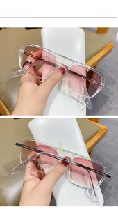 Detail of pink gradient aviator sunglasses with transparent frames and white leather case