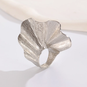 Macro shot of silver ginkgo leaf ring featuring detailed metal textures and polished finish