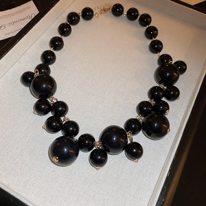Exaggerated irregular black pearl cluster necklace with gold metal rings in a gift box