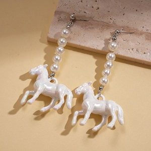 Détail macro de boucles d'oreilles en perles avec pendentif cheval en résine irisée