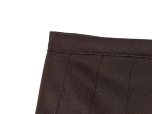Dettaglio della cucitura in vita e trama twill su una gonna lunga a pieghe marrone