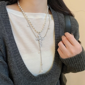 Détail du collier double rang avec pendentif croix baroque et glands en perles