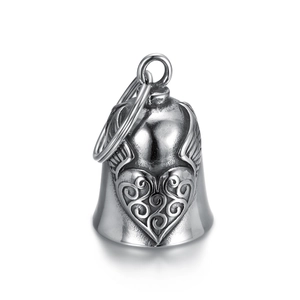 Close-up of silver stainless steel bell pendant with embossed heart and wings design