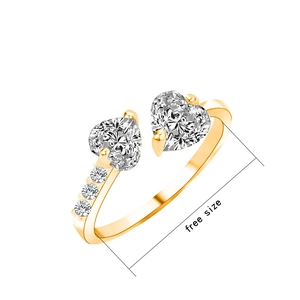 Sparkling golden open ring with heart-shaped cubic zirconia stones on white background