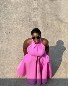 Top view of pink halter maxi dress with lapel collar and button details on paved floor