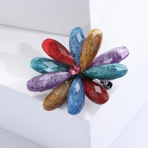 Detail of colorful acrylic flower brooch with textured petals and pink rhinestone center