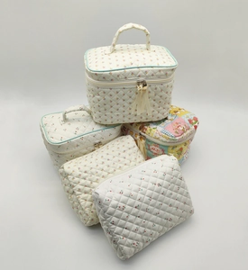 Detailed stack of quilted cotton cosmetic bags with cherry and floral prints and tassels