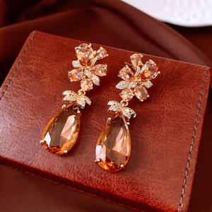 Gros plan de boucles d'oreilles vintage avec zircon ambre sur une boîte cadeau