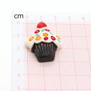 Resin fruit cupcake pendant with cherry top shown on a centimeter measurement mat