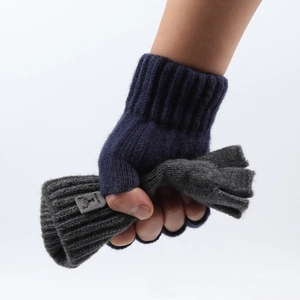 Close-up of thick knitted fingerless gloves with ribbed cuffs and decorative brand label
