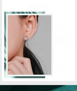 Close-up of minimalist sterling silver hoop earrings with pave-set turquoise stones on model
