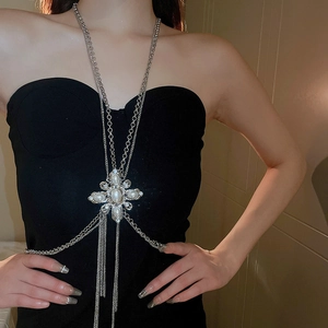 Close-up of elegant silver body chain featuring rhinestones and pearl details on model