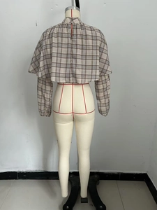 Detail of grey-brown checkered cropped blouse with back slit and natural fabric texture