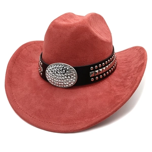 Close-up of brick red suede cowboy hat with studded leather band and rhinestone buckle