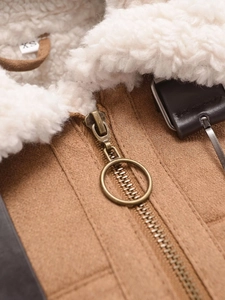 Detail von Lammfellkragen und Metallreißverschluss an brauner Wildlederjacke
