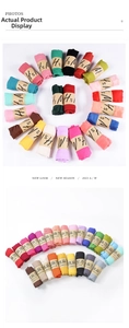 Detailed view of colorful pleated cotton linen scarves rolled with paper band labels
