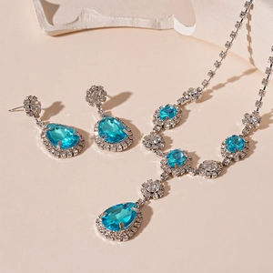 Macro view of vintage teardrop pendant necklace and earrings set with blue gemstones