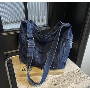 Gros plan détaillé sur la texture denim bleu foncé avec bords effilochés et boucle argent