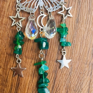 Close-up of butterfly suncatcher with silver moon, crystal beads and green gemstones