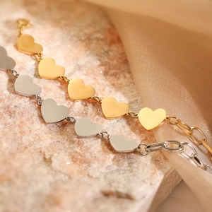 Minimalist 18K gold and silver heart pendant bracelets on elegant silk background
