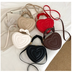 Flachbild von herzförmigen gesteppten Handtaschen mit Raffbügeln in fünf Farben