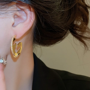 Close-up of 18K gold plated C-shaped geometric earring with white zircon micro-inlay