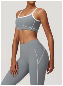 Détail des coutures blanches contrastées sur le pantalon de yoga gris et le haut de sport