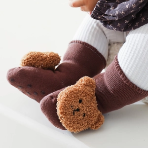 Dettaglio di calzini per neonati con orsetto di peluche e fondo antiscivolo