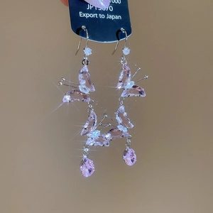 Macro shot of pink butterfly drop earrings with shimmering crystals and silver needles