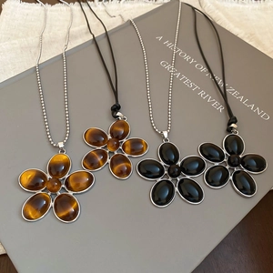 Detailed close-up of resin flower pendants in brown tiger eye and black onyx style