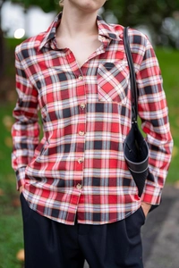 Close-up of red and black plaid shirt featuring a button-down collar and chest pocket