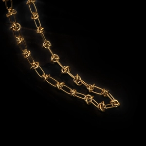 Chic 18K gold knotted thorn chain necklace with minimalist hip-hop style on black background
