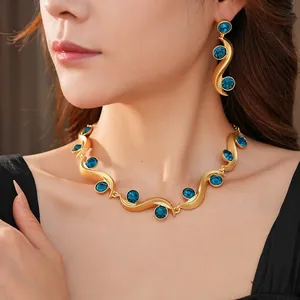 Vintage gold wavy jewelry set with blue gems worn by model for luxury fashion styling