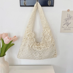 Close-up of white lace daisy tote bag with delicate floral embroidery and ruffled edges