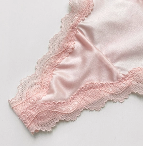 Detail of pink satin and lace thong with heart ornament and delicate mesh texture
