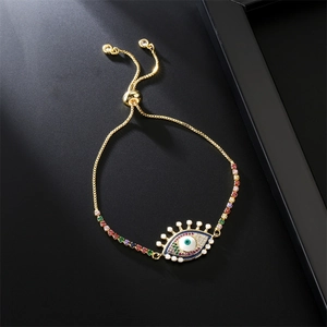 Detail of adjustable gold-plated chain bracelet featuring a colorful zirconia evil eye charm