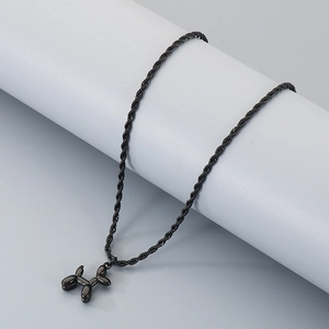 Détail du pendentif chien ballon noir brillant sur une chaîne torsadée et socle gris