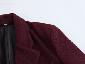 Detailed close-up of wine red blazer collar with padded shoulders and woolen fabric texture