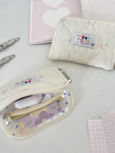 Quilted cream wallet with colorful star stitching and multi-pocket internal storage
