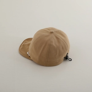 Detail of baby bear baseball cap showing adjustable drawcord and soft khaki fabric texture
