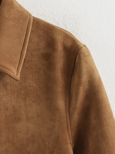 Gros plan sur la texture en daim marron et les coutures du revers de la veste vintage